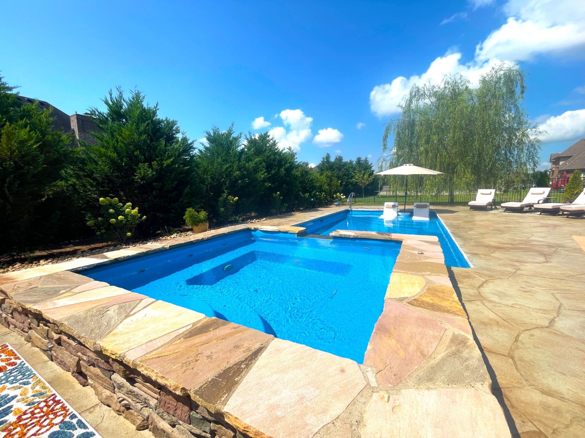 Stone-trimmed spa and Aspen pool installation with lounge area in Murfreesboro TN