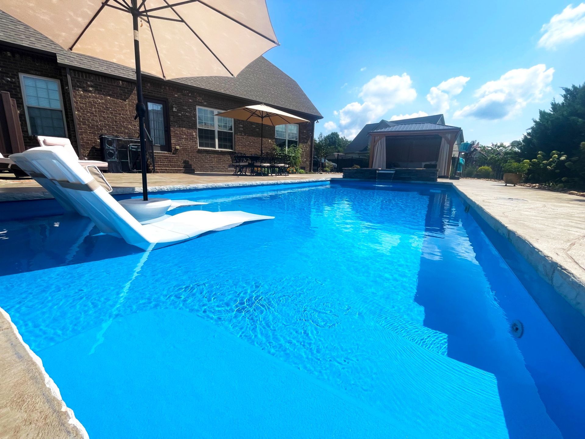 Sun shelf loungers with umbrella on Aspen pool ledge in Murfreesboro TN