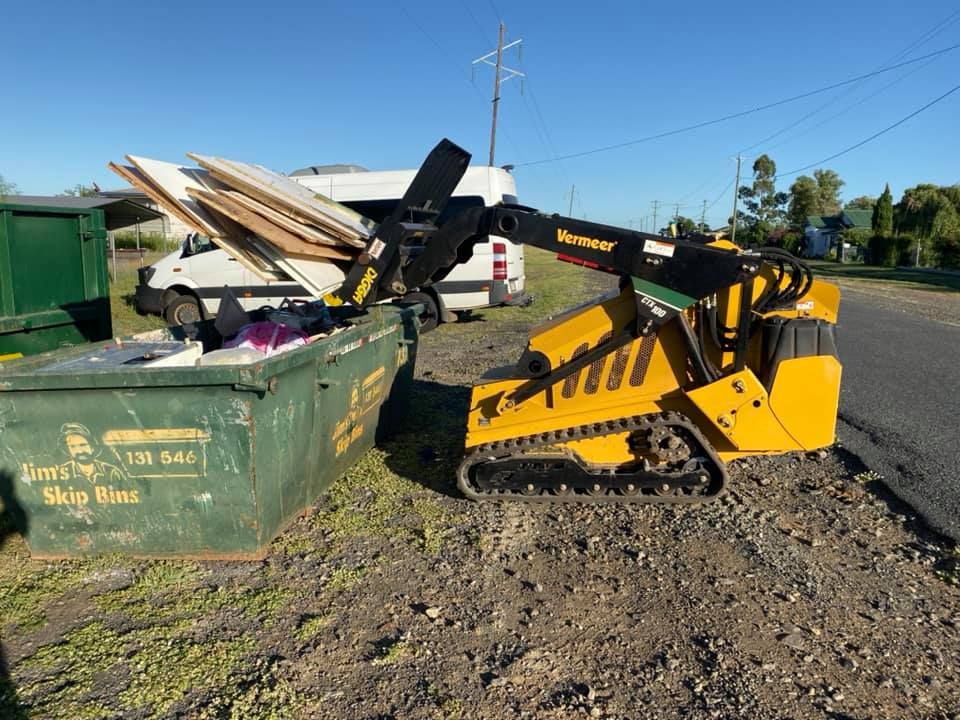 A Bulldozer is Parked Next to a Green Dumpster — Restore All Qld in Kingaroy, QLD