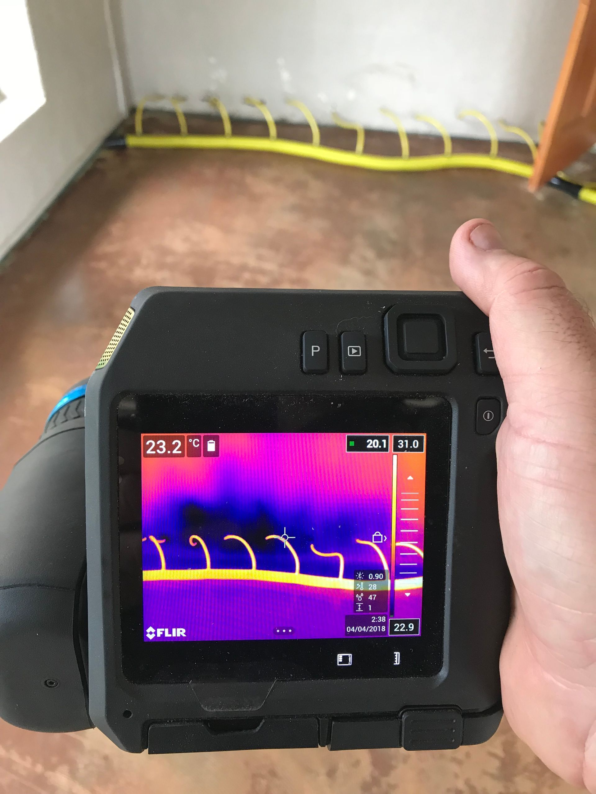 Thermal camera showing heat signature of underfloor heating system, purple and yellow colors.
