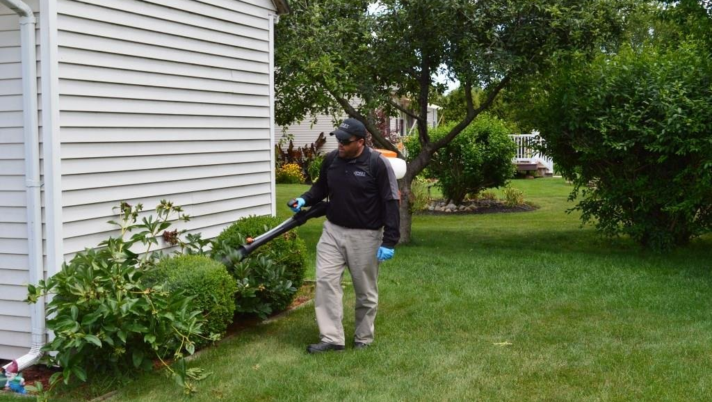 Pest Assassins technician treating customers home for mosquito control in Dover, MA
