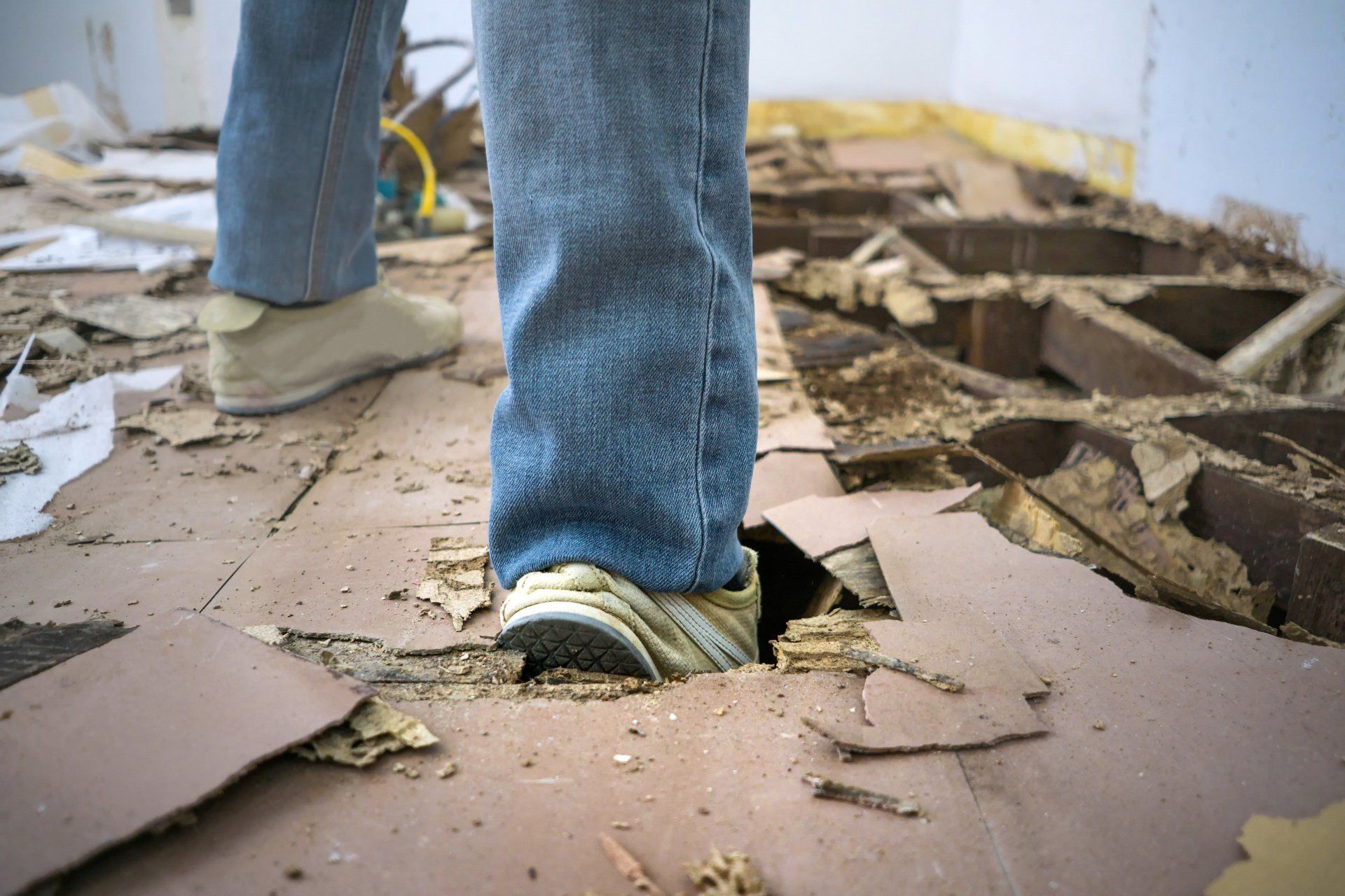 Pest Assassins customer walking on a floor damaged by termites. 