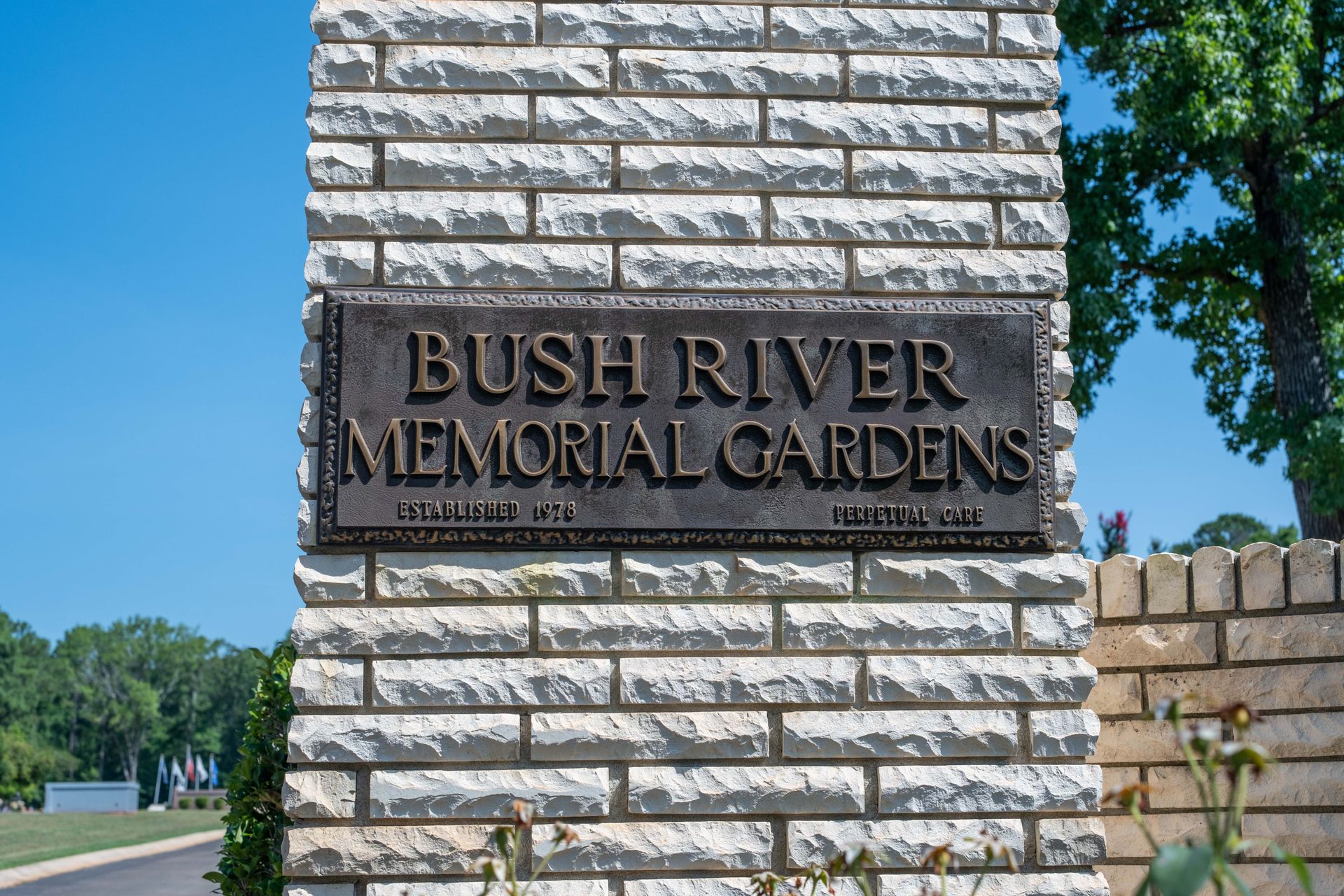 Sign for Bush River Memorial Gardens on a brick pillar.