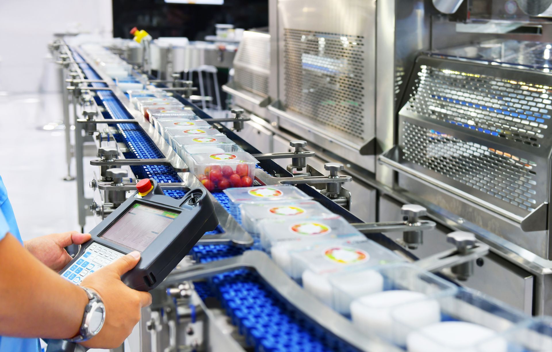 A person is operating a conveyor belt in a factory.