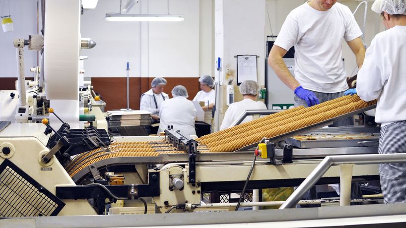 A group of people are working on a machine in a factory.