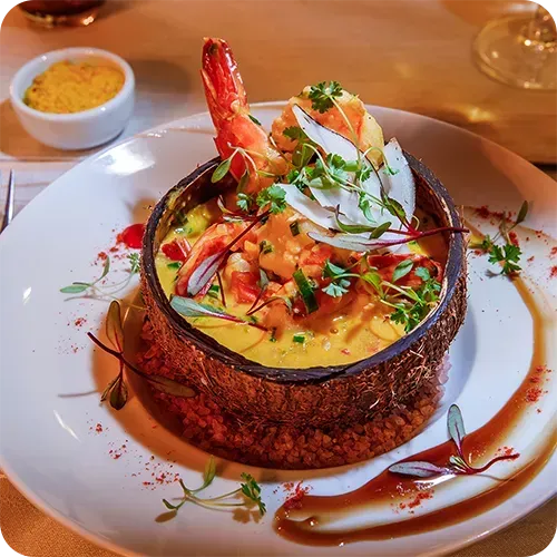Um prato de comida com camarão em casca de coco