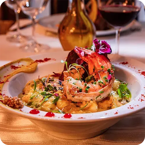 Uma tigela de comida com camarão e arroz sobre uma mesa.