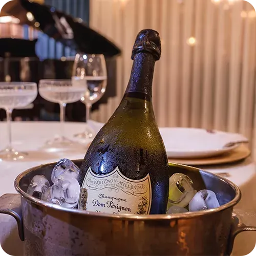 Uma garrafa de champanhe está em um balde de gelo.