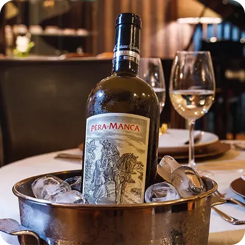 Uma garrafa de vinho pera-manca em um balde de gelo