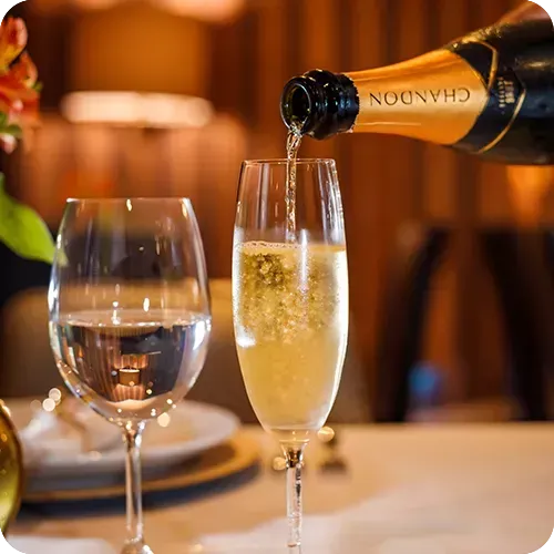 Uma garrafa de champanhe Chandon está sendo servida em uma taça.