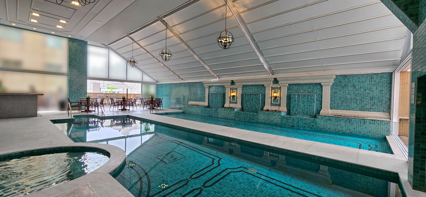 Uma grande piscina interior com jacuzzi ao lado.