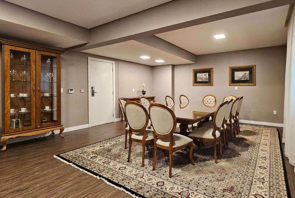 Uma grande sala de conferências com cadeiras vermelhas e uma tela de projetor