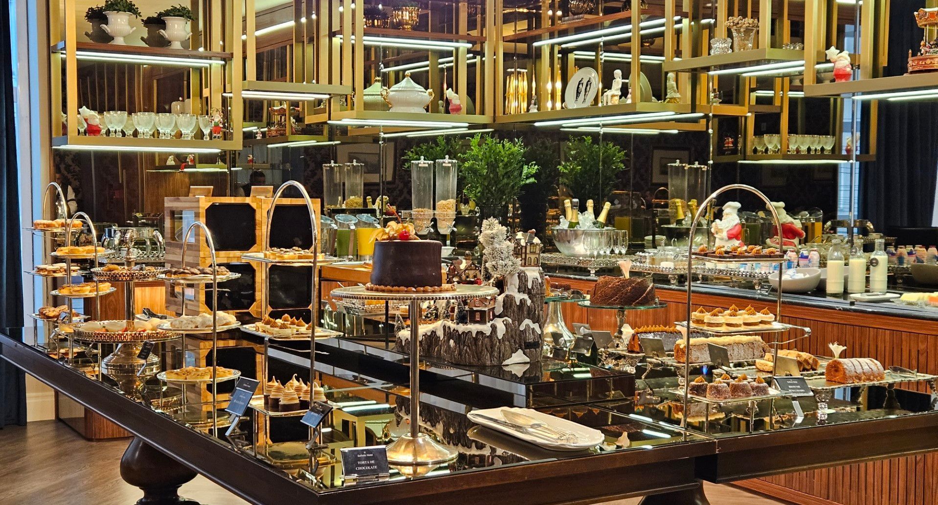 Uma mesa de buffet repleta de muita comida e sobremesas.