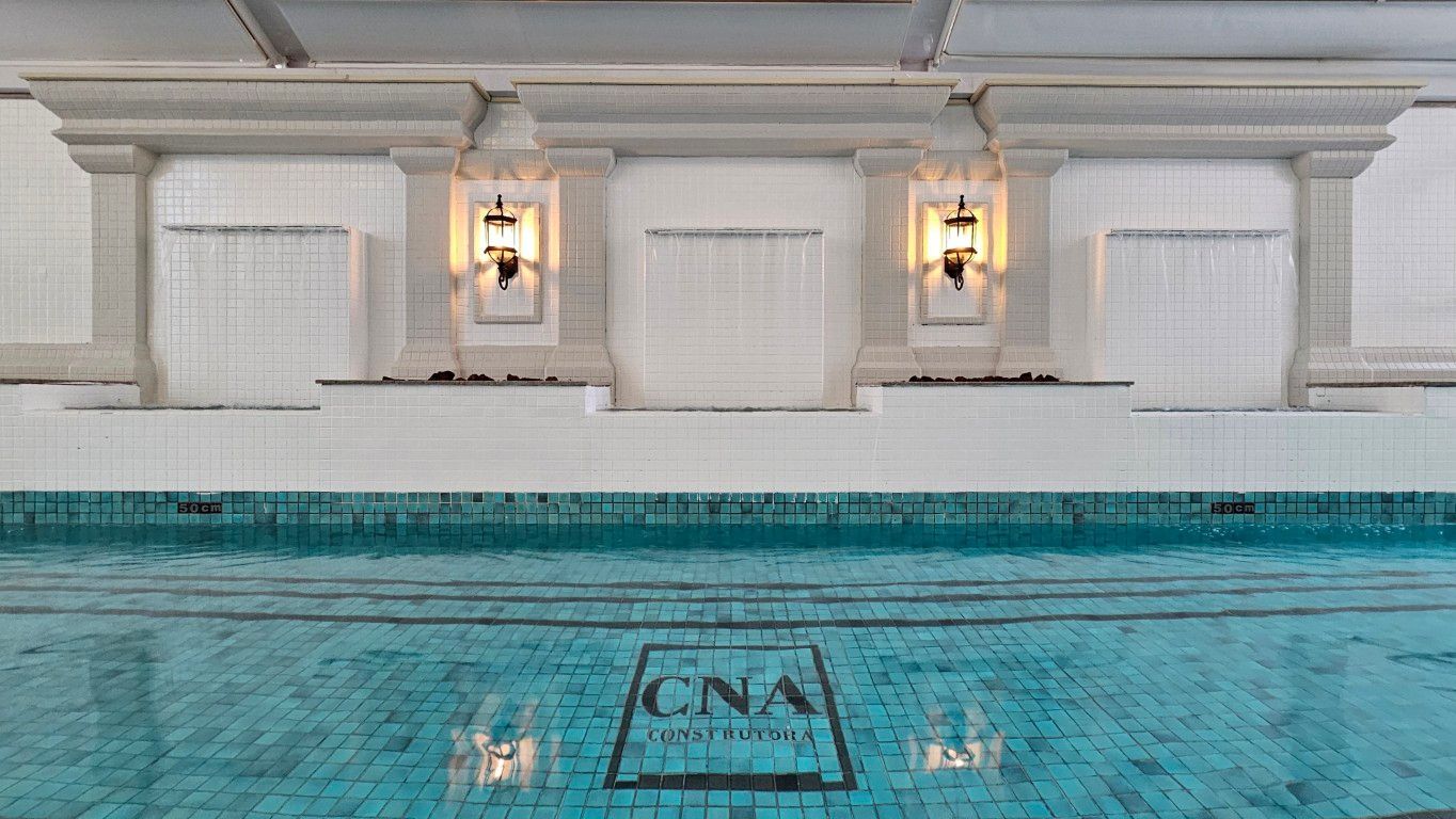 Uma grande piscina interior com mesa e cadeiras em frente.