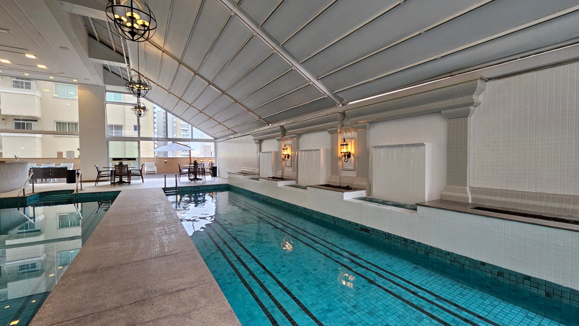 Uma grande piscina interior com jacuzzi ao lado.