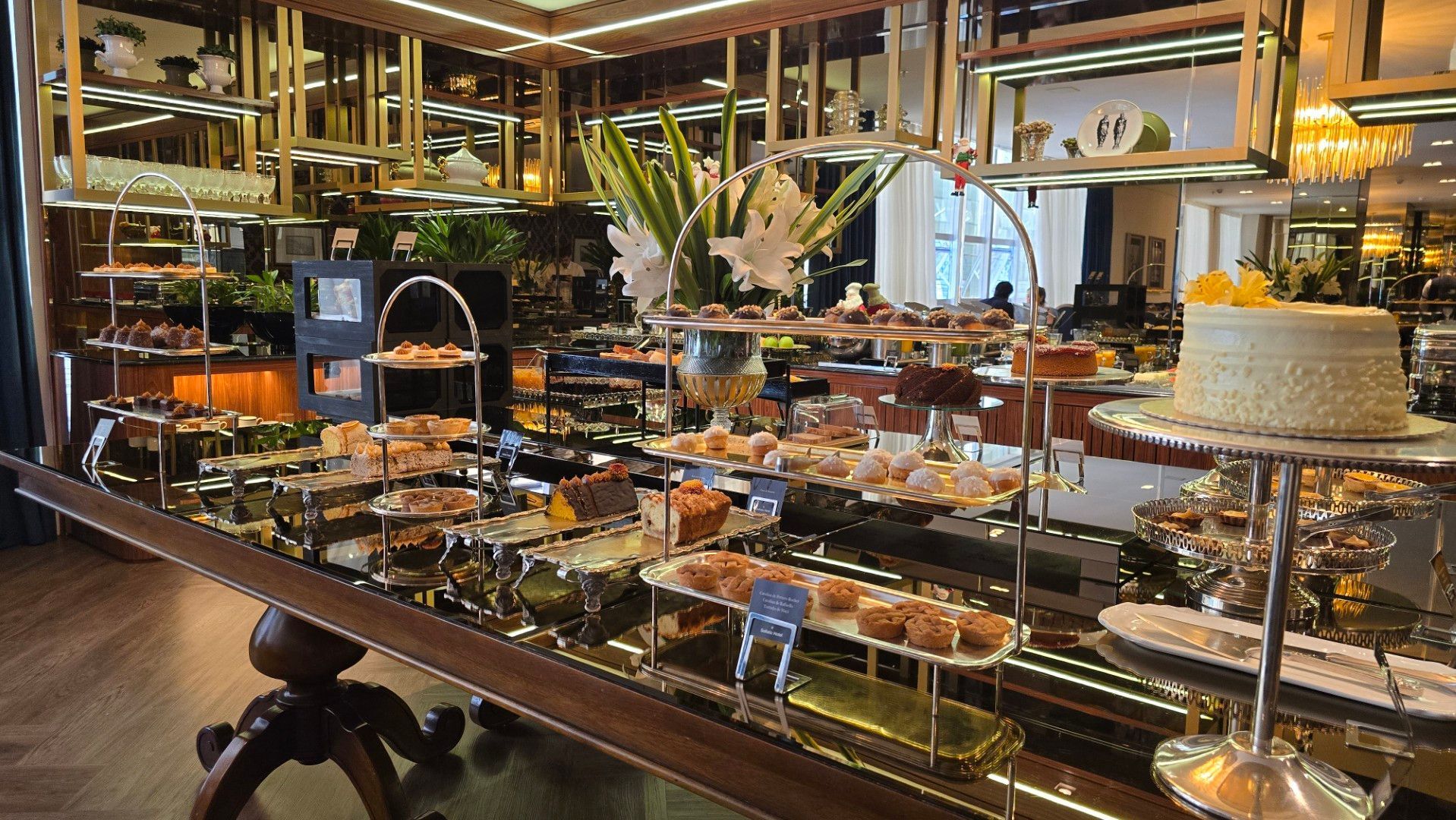 Uma mesa de buffet repleta de muita comida e sobremesas.