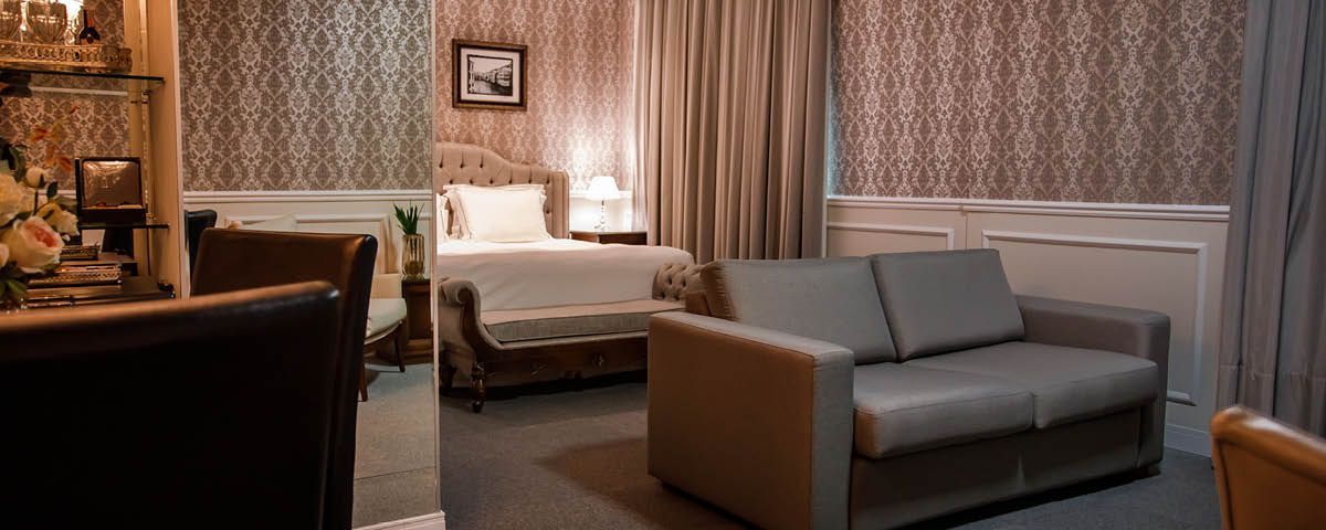 Um quarto de hotel com sofá, cadeiras e uma cama.