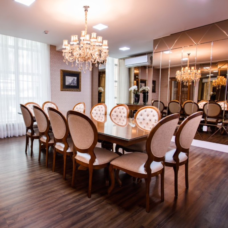 Sala de jantar sofisticada com lustre e espelhos grandes.