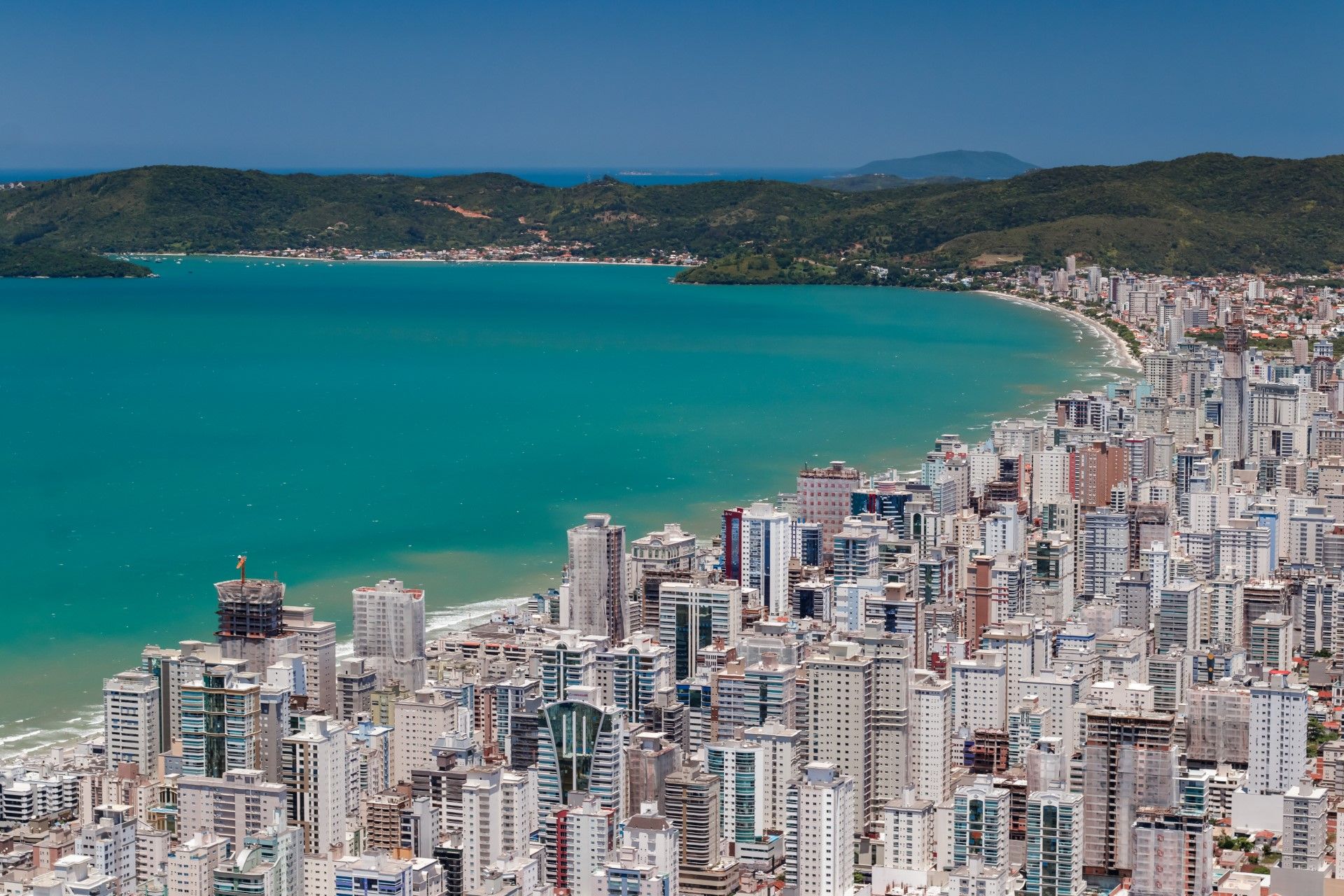 Uma vista aérea de uma cidade com um grande corpo de água ao fundo.