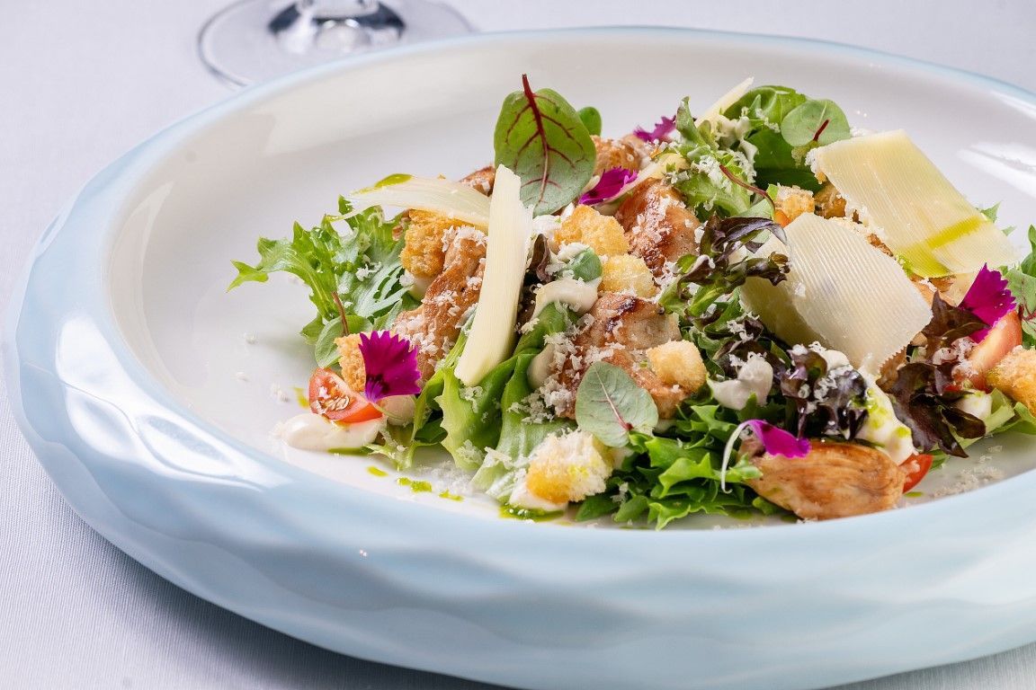 Um close de uma salada em um prato sobre uma mesa.