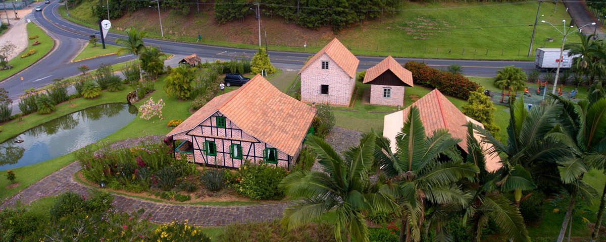 Uma vista aérea de uma casa no meio de um campo verdejante.