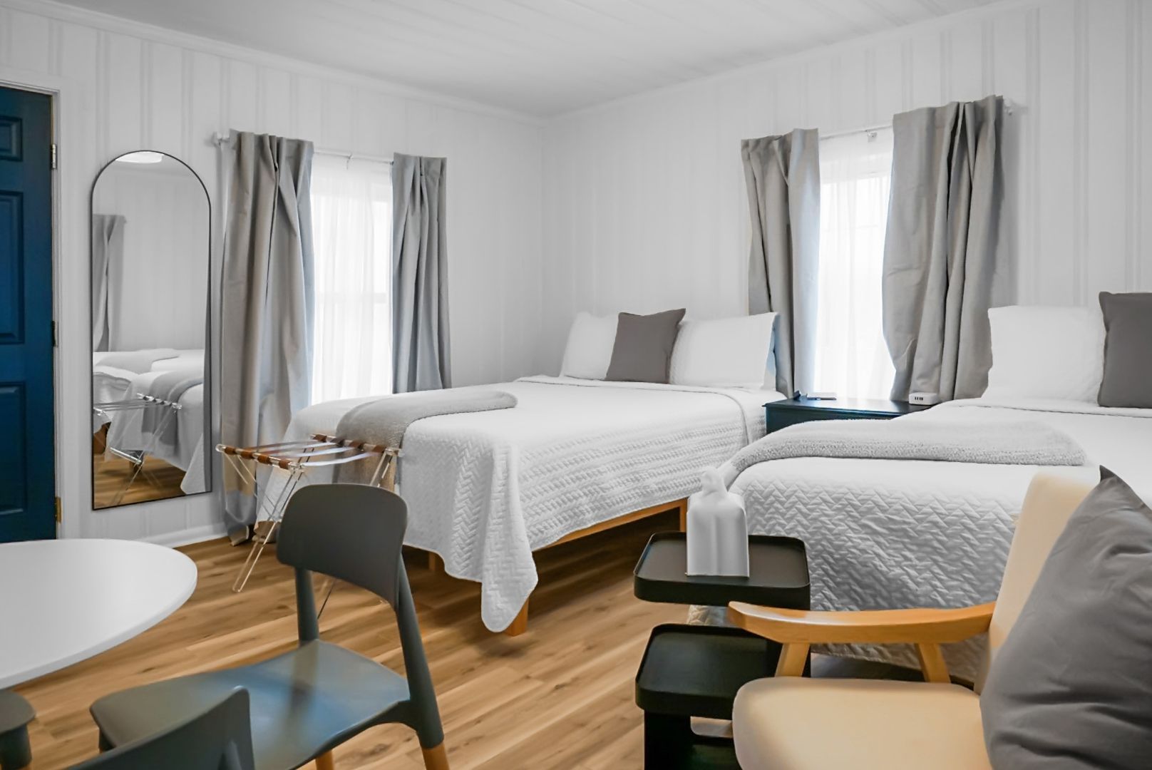 A bedroom with a bed , desk , lamp and mirror.