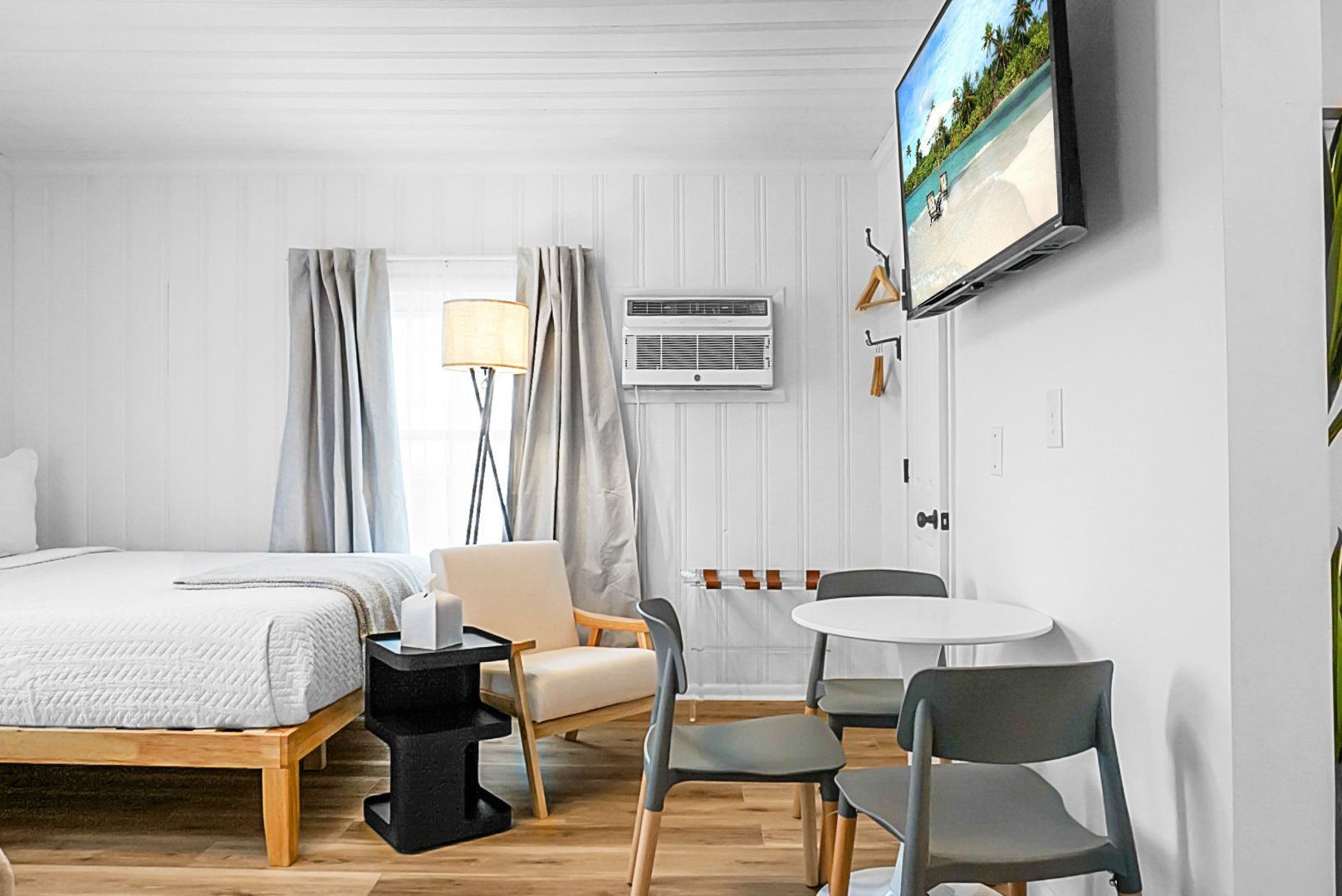 A bedroom with a bed , nightstand , lamp and television.