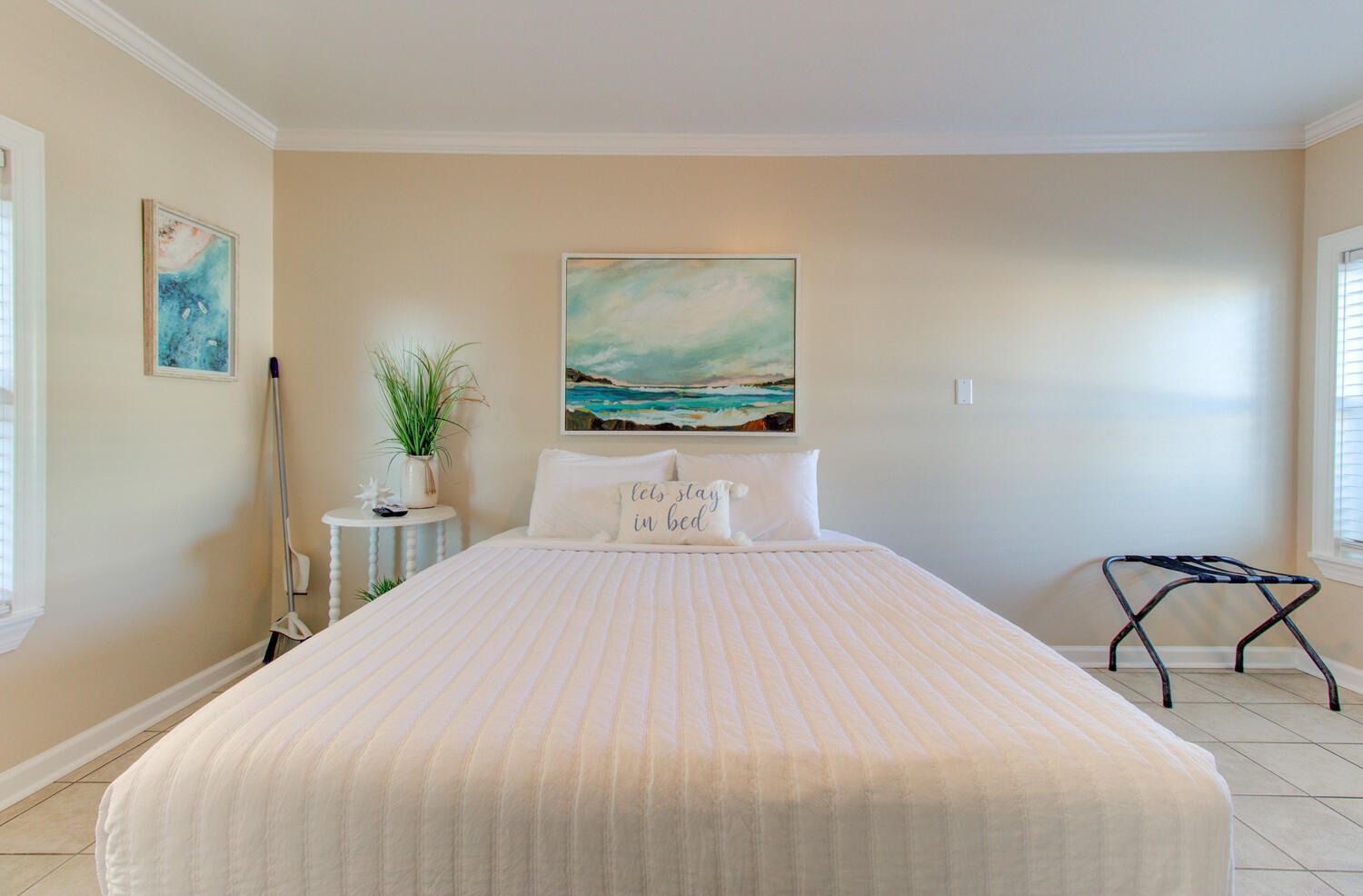 There is a painting on the wall above the bed in the bedroom.