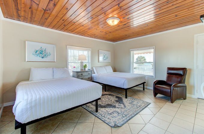 There are two beds and a chair in the room.