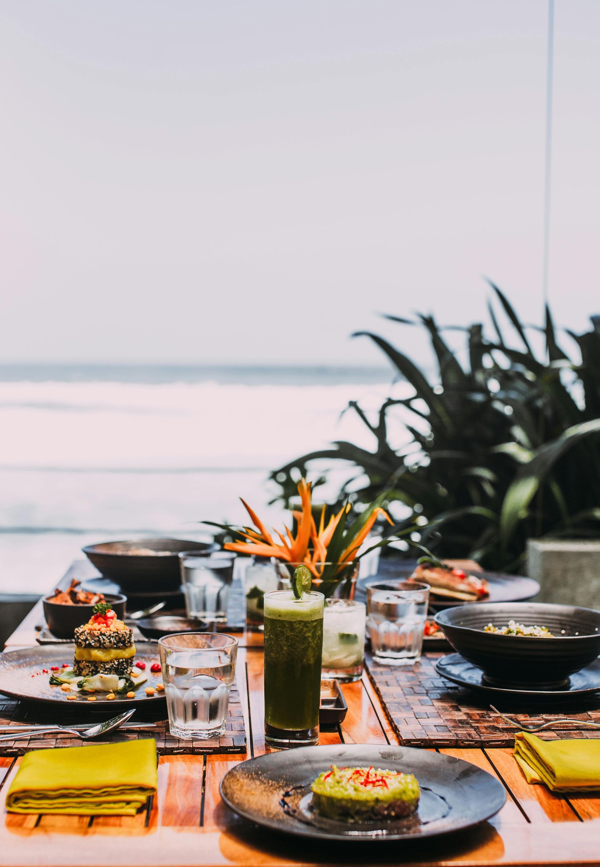 A wooden table with plates of food and drinks on it.