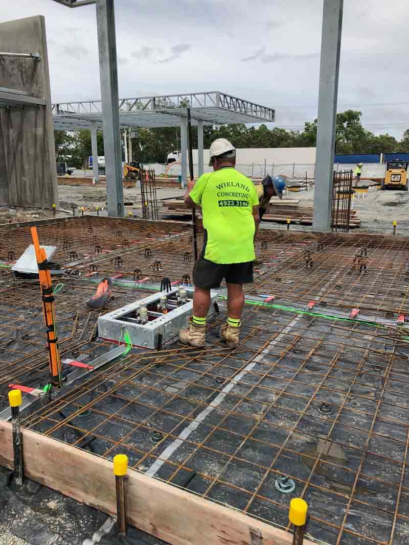 Construction Worker in Neon Shirt Inspecting Concrete Work — Wieland Concreting in Rockhampton, QLD