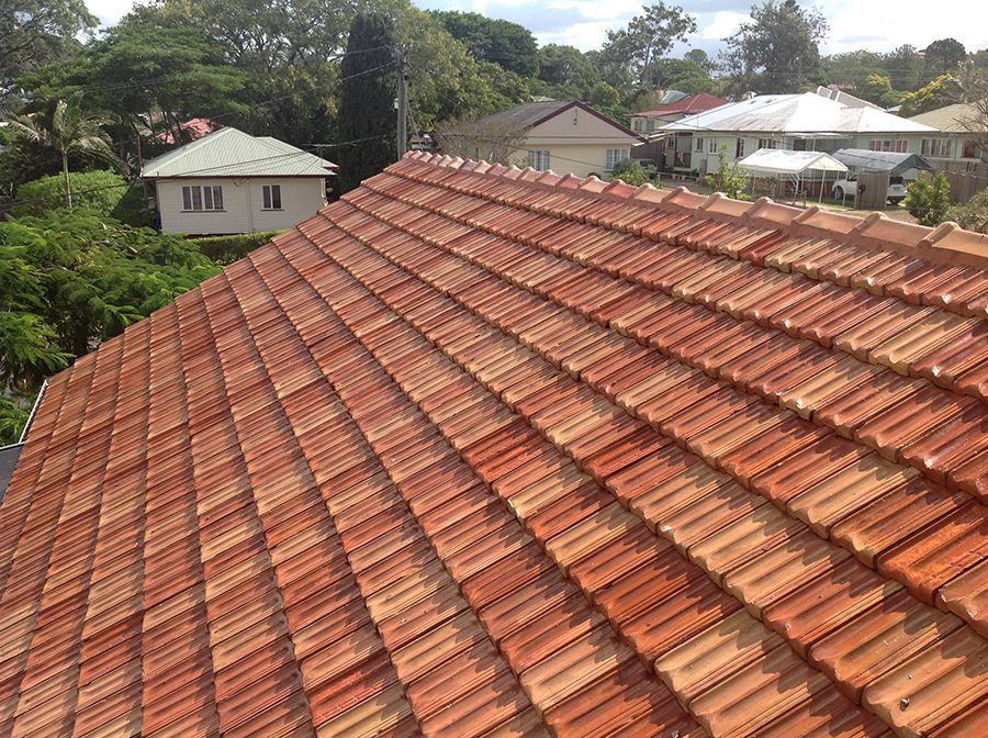 A roof with a lot of tiles on it and houses in the background.