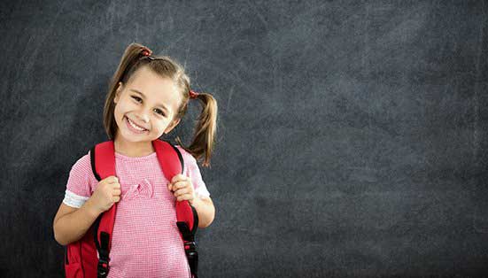 Smiling little girl in front of the board — Wilmington, NC — Kids & Company