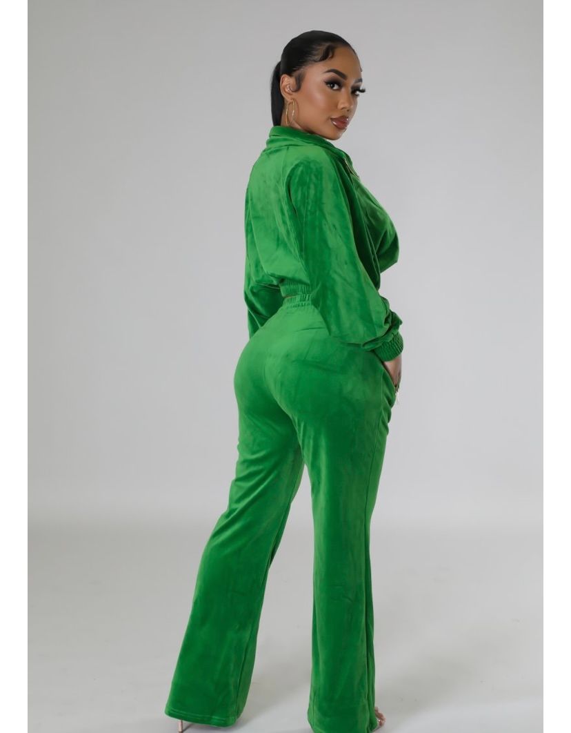 A woman is wearing a green velvet tracksuit.