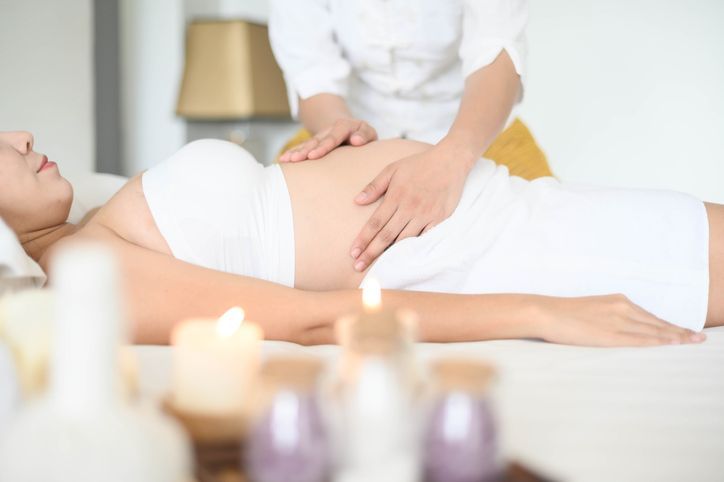 Pregnant woman having massage in spa relax