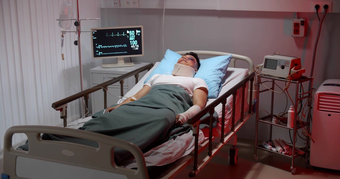 A man is laying in a hospital bed with a bandaged head.