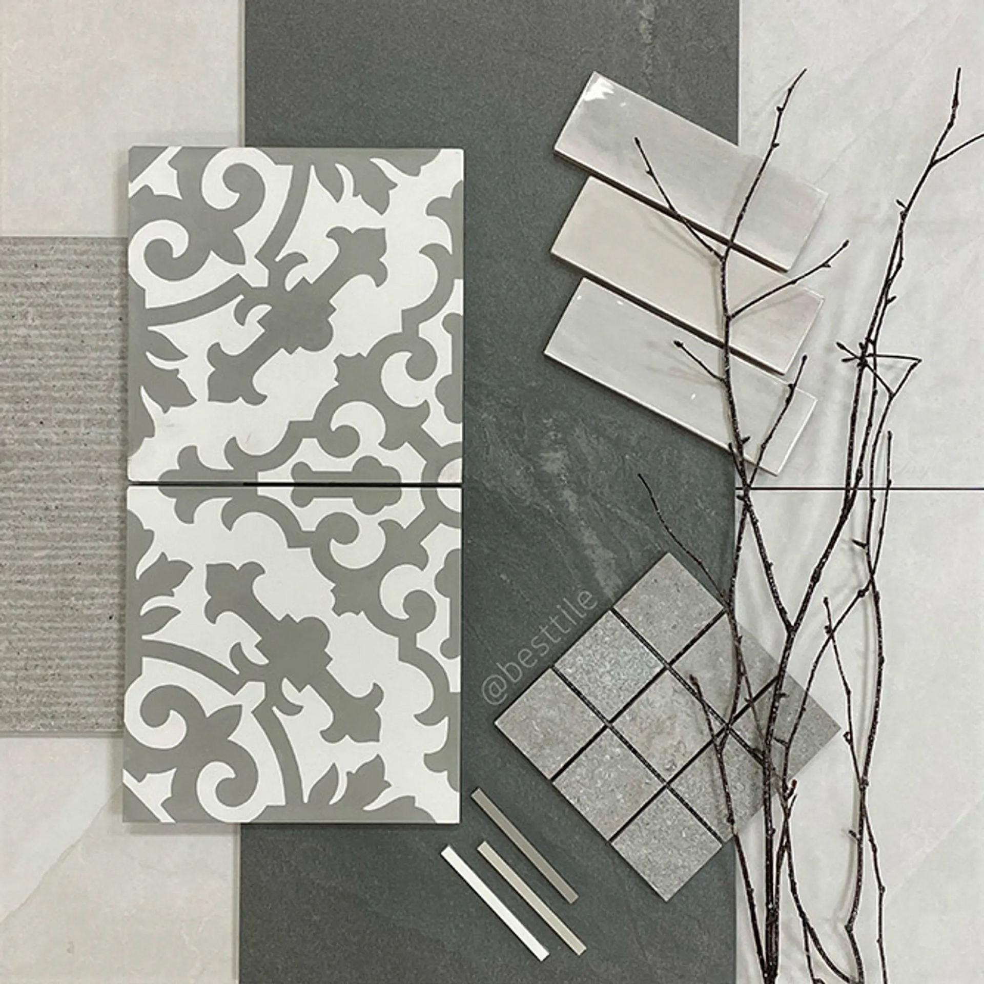Tile samples in shades of gray, including patterned and square tiles, with twigs.