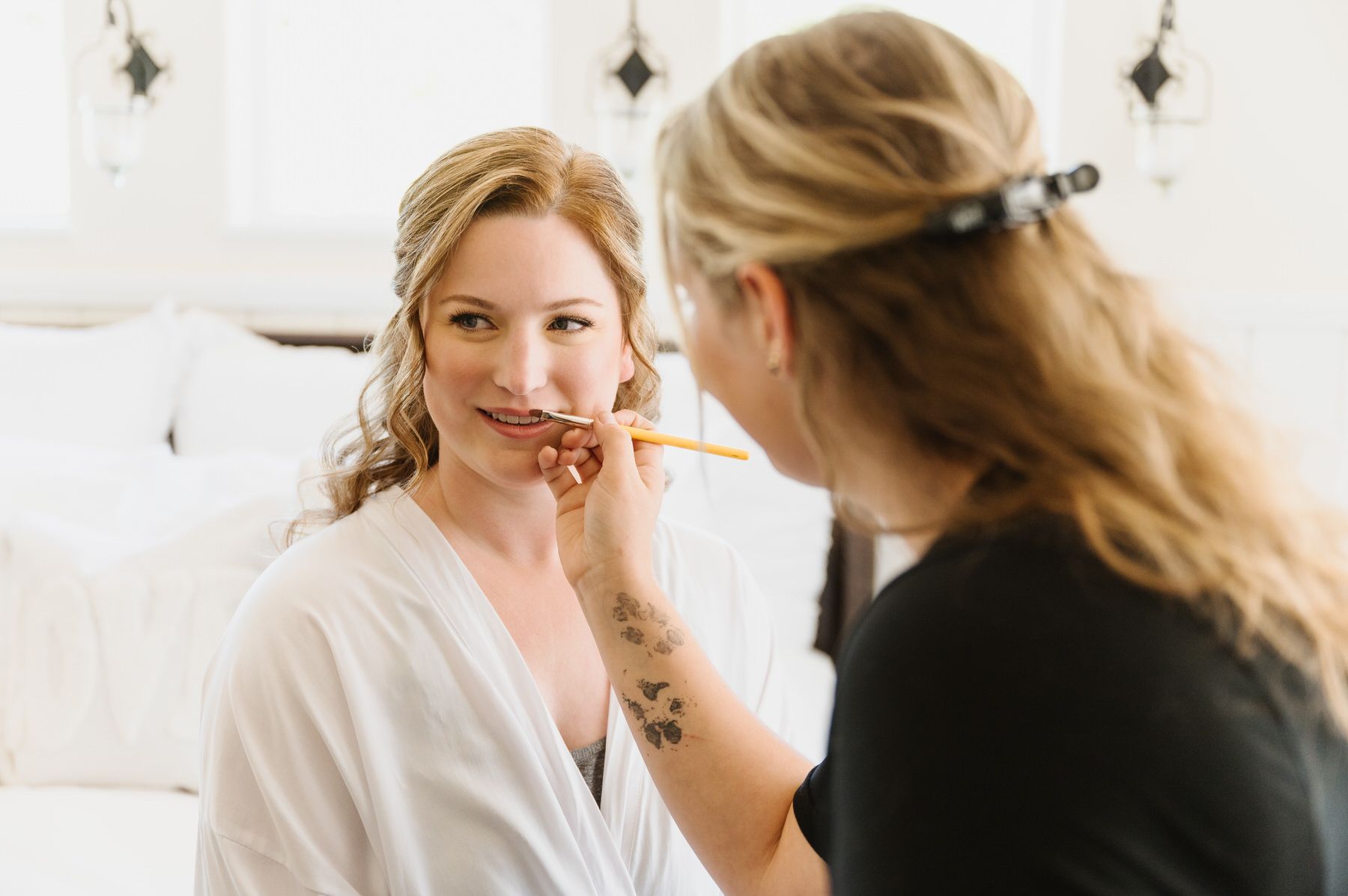 A woman is getting her makeup done by a makeup artist. Orange county hair and makeup artist.