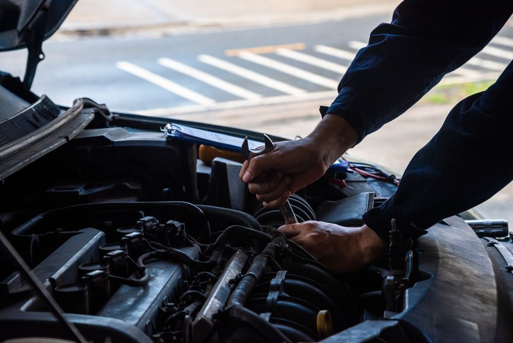 Person working on a car engine with a wrench under the hood  — Precision Tuning in Bungalow, QLD