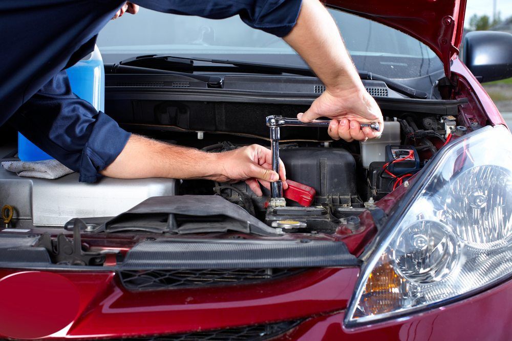 Mechanic Working Under A Car’s Open Hood, Inspecting The Engine Compartment — Precision Tuning in Bungalow, QLD