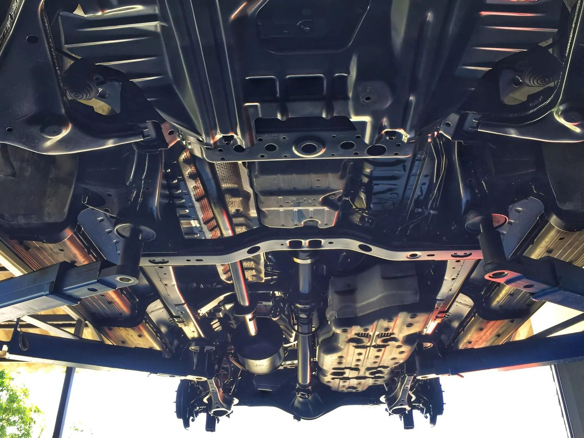 A Vehicle Lifted on A Hydraulic Lift, Showing Black Chassis and Components — Precision Tuning in Bungalow, QLD