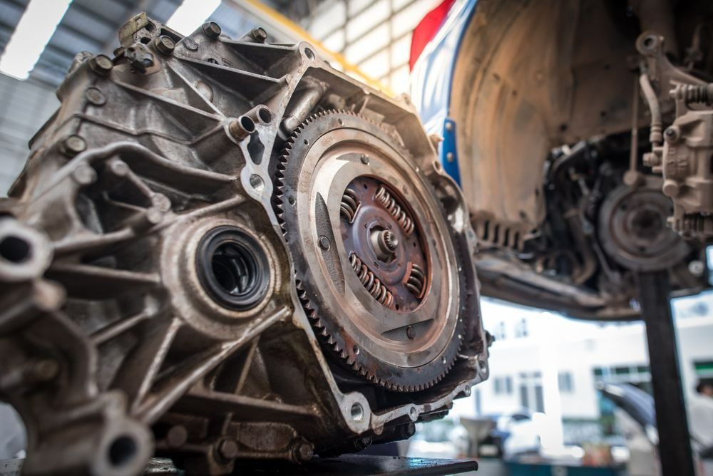 A Car Transmission with Exposed Gears, Partially Under a Vehicle in A Repair Shop — Precision Tuning in Bungalow, QLD