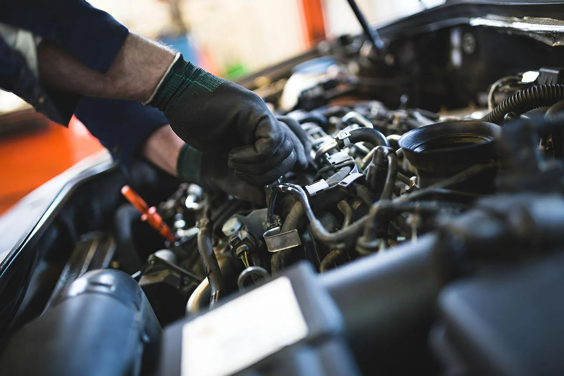 Mechanic with Gloved Hands Working on A Car Engine with The Hood Open — Precision Tuning in Smithfield, QLD
