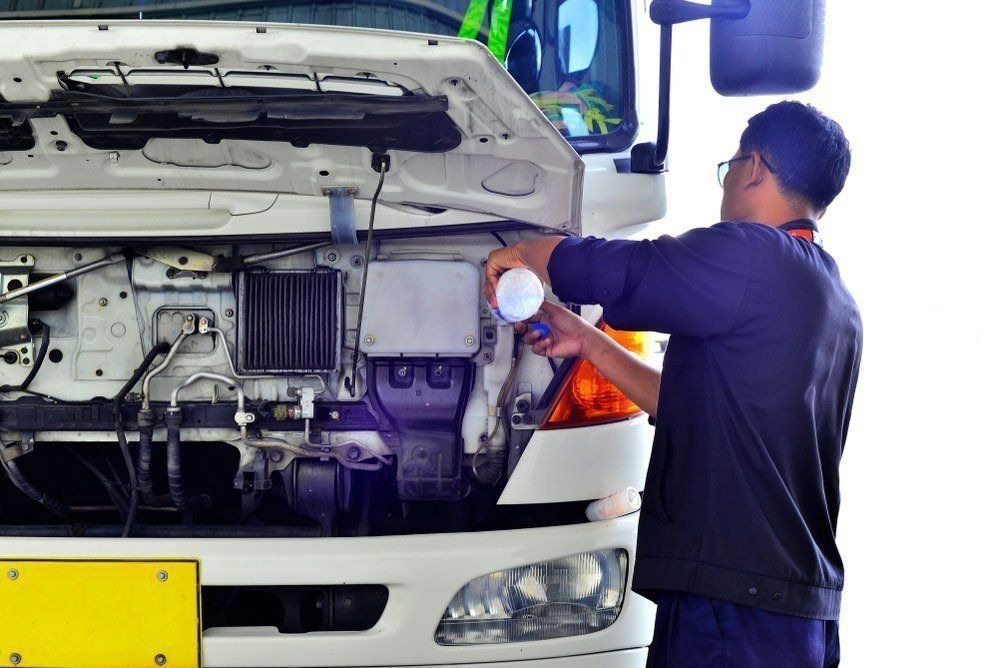 Mechanic Working on The Open Hood of A White Truck — Precision Tuning in Bungalow, QLD