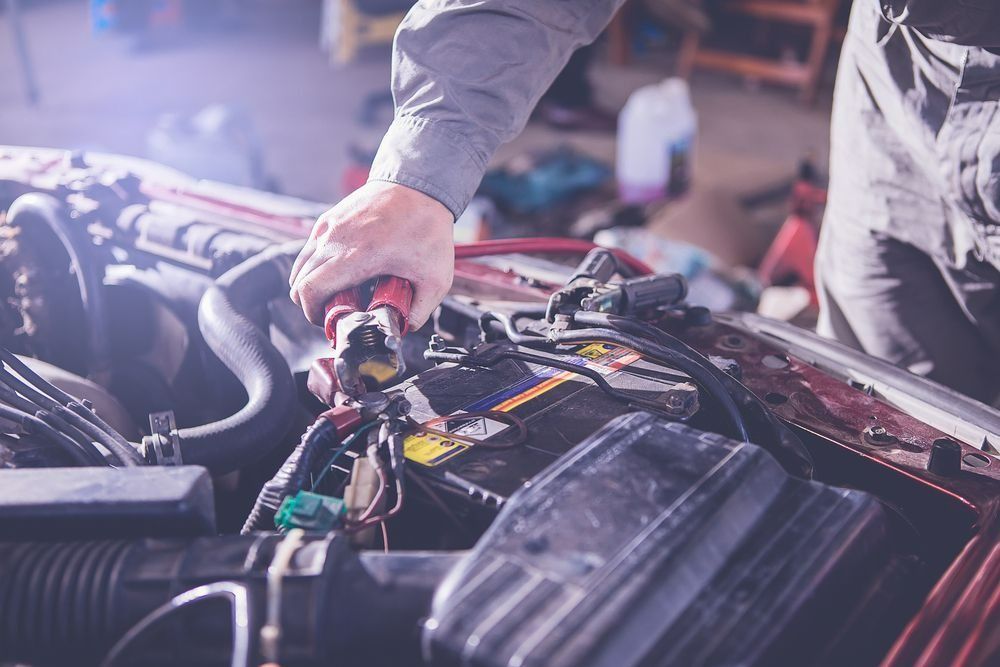 Mechanic Working on Car Engine, Using Tool on Battery in A Garage — Precision Tuning in Edmonton, QLD