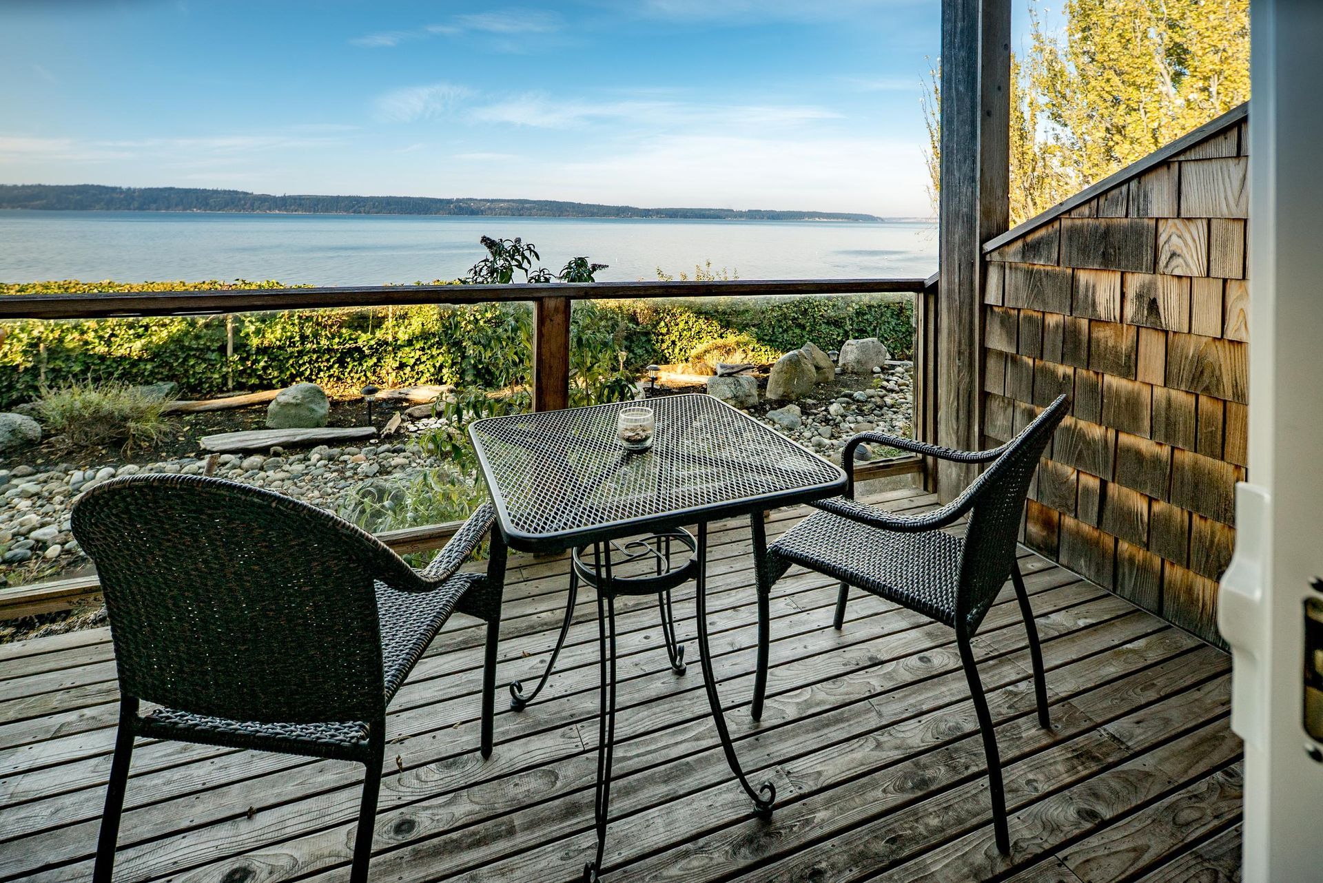 A sunset over a body of water with the sun shining through the clouds.