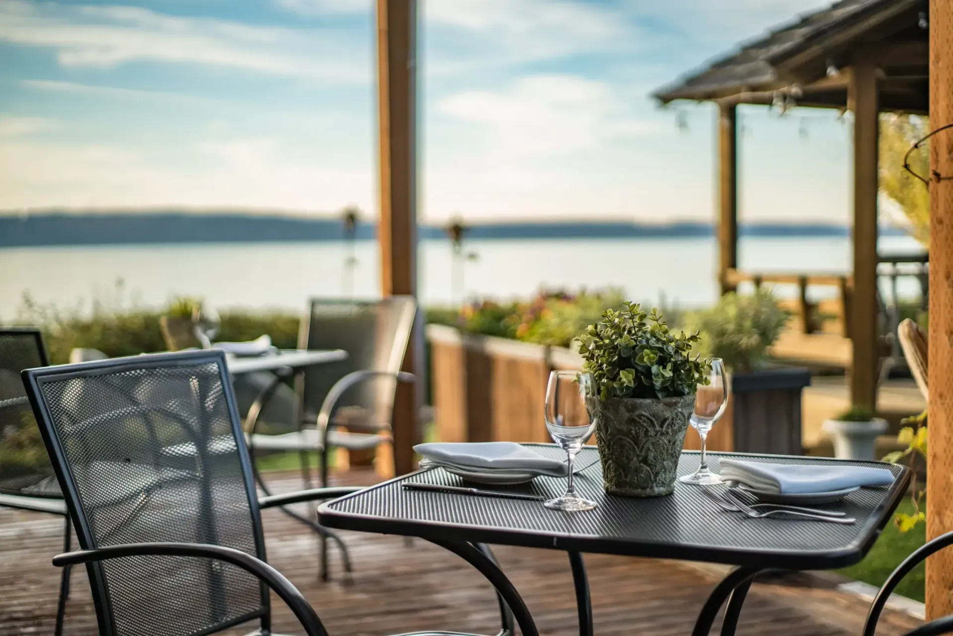 A table and chairs on a patio overlooking the ocean.