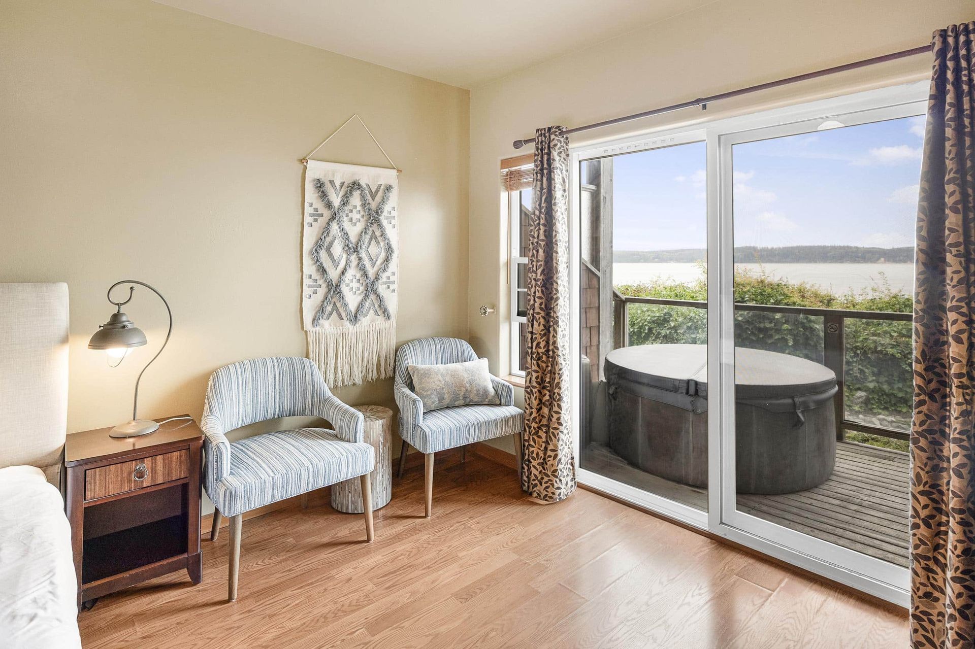 There is a hot tub on the deck with a view of the ocean.