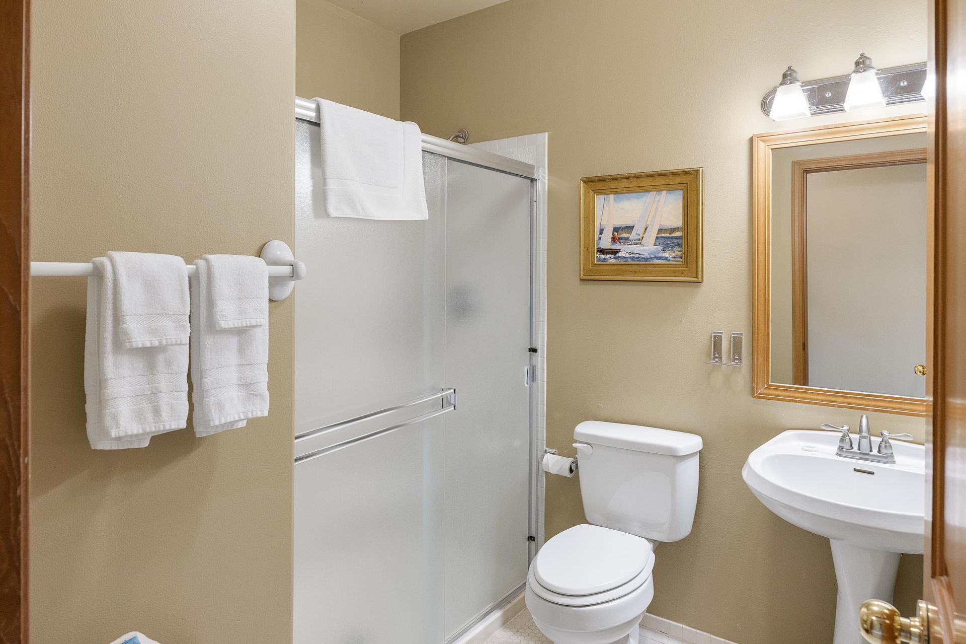 A living room with a sliding glass door leading to a balcony overlooking the ocean