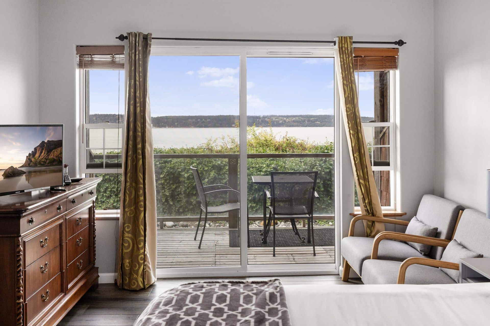 Two chairs and a table on a balcony overlooking a body of water